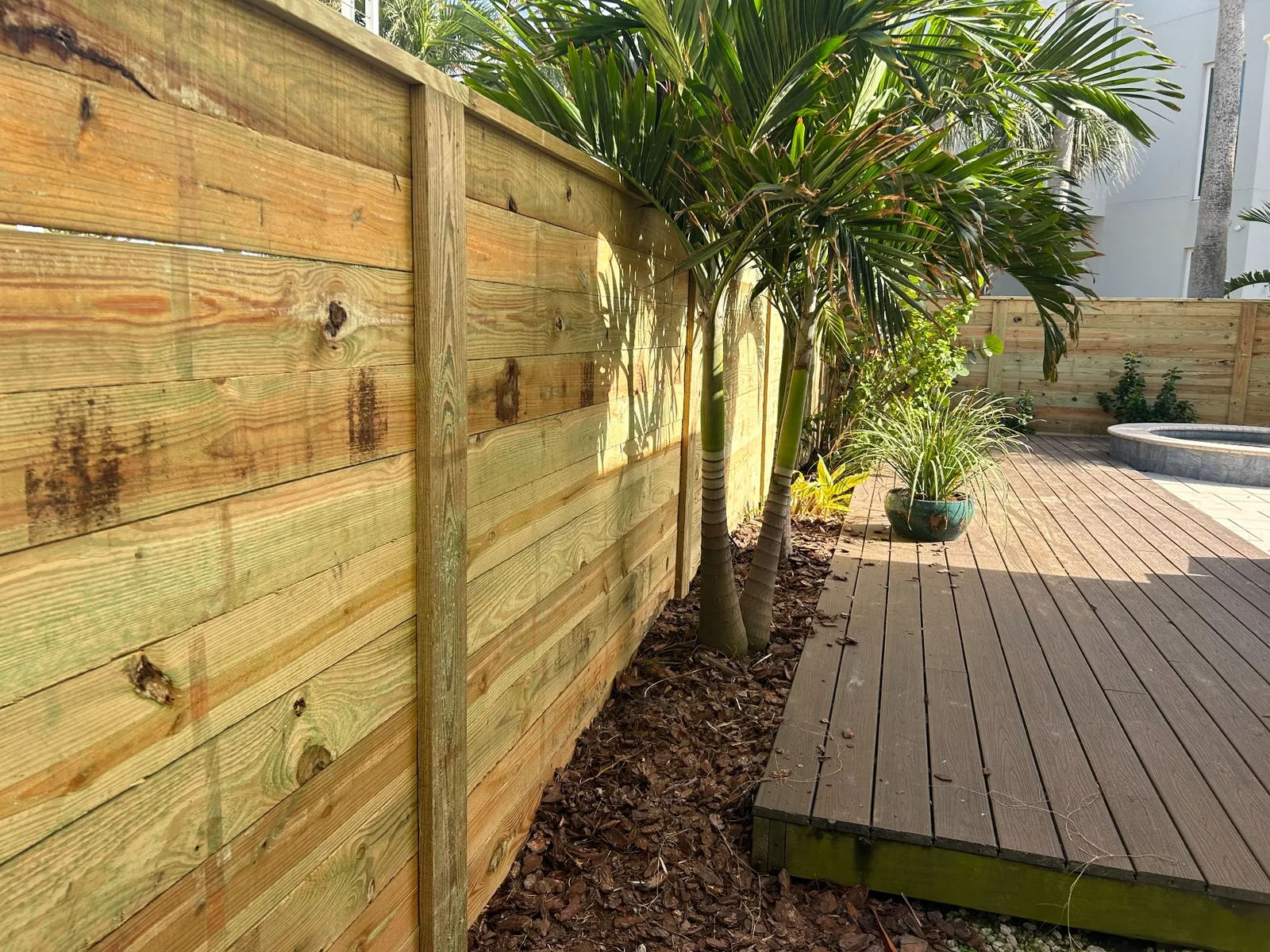 Wood fencing beside an outdoor deck by Cypress Building Group